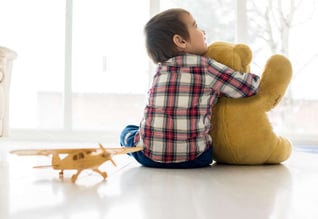 Portrait of child sitting in living room with Teddy bear_11zon